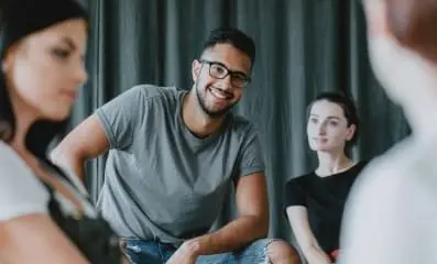 Smiling man in gray shirt. Text: Look for treatment providers who specialize in addressing both drug addiction and mental health disorders.