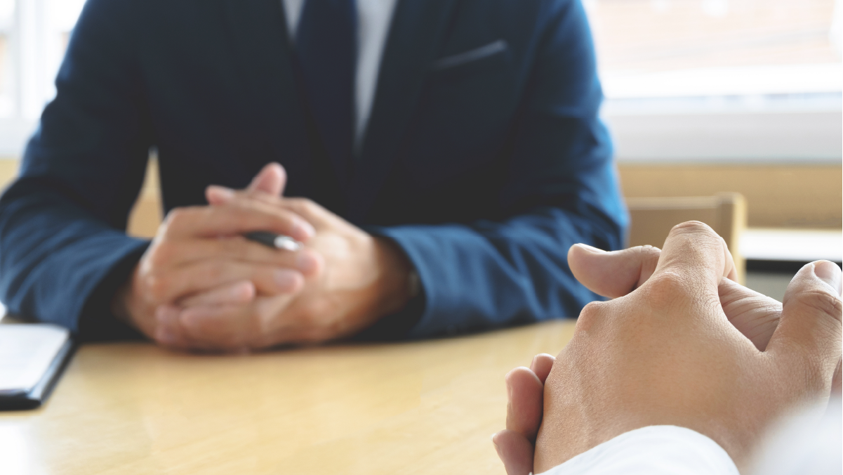 A doctor talking to a patient in a clinical setting with both parties with clasped hadns