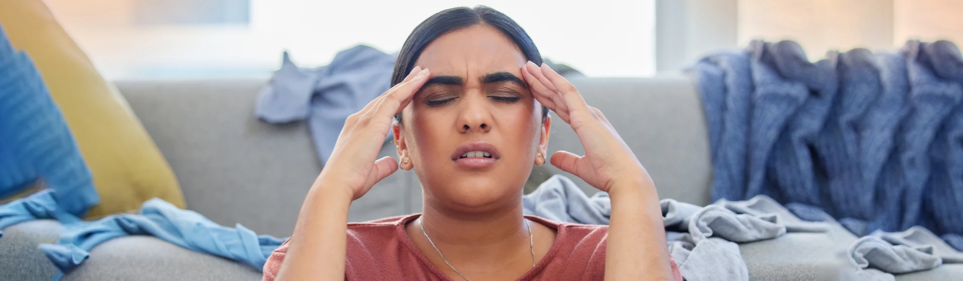 A person holding their head in their hands, looking tired and stressed.