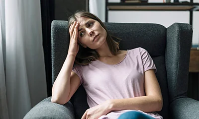 A person holding their head in their hands, looking tired and stressed.