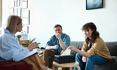 A group of people sitting in a circle, practicing mindfulness meditation, with a therapist guiding the session.