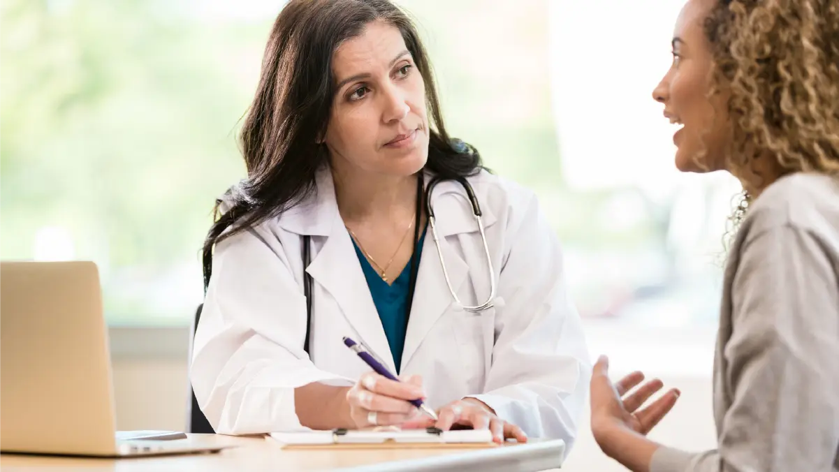 A doctor talking to her patient with a concerned look