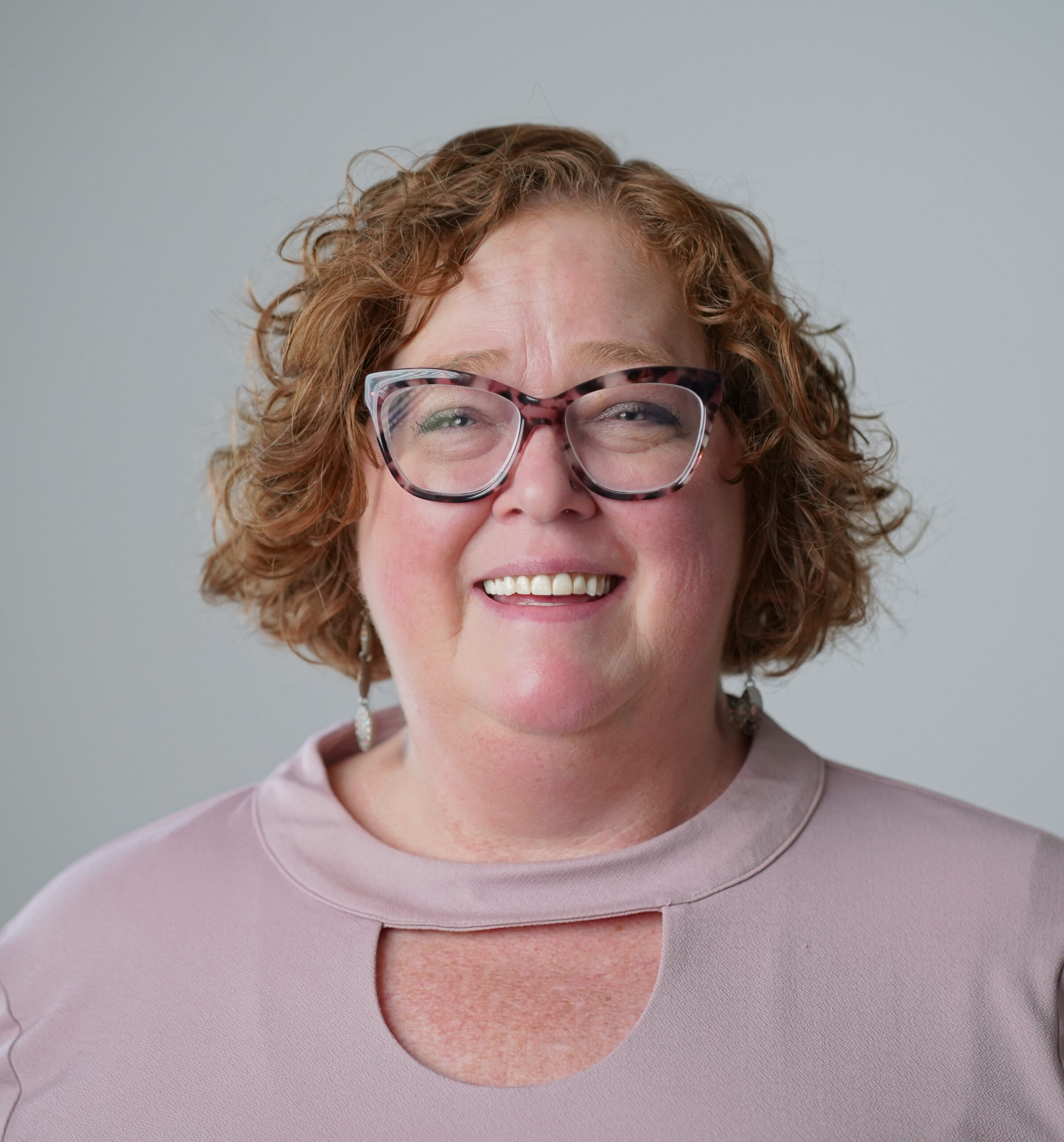 a woman wearing glasses and smiling