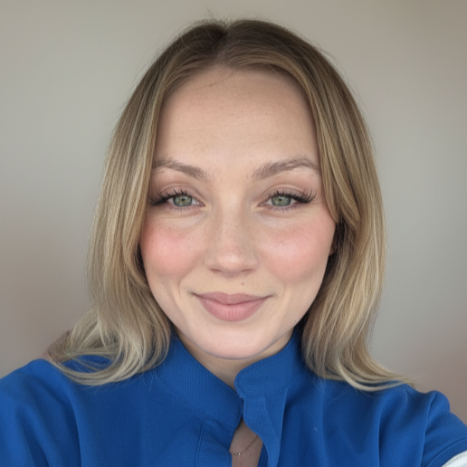 Professional headshot of a smiling woman with blonde hair wearing a blue top against a neutral background.